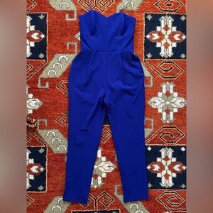 Strapless blue jumpsuit with pleated pants.